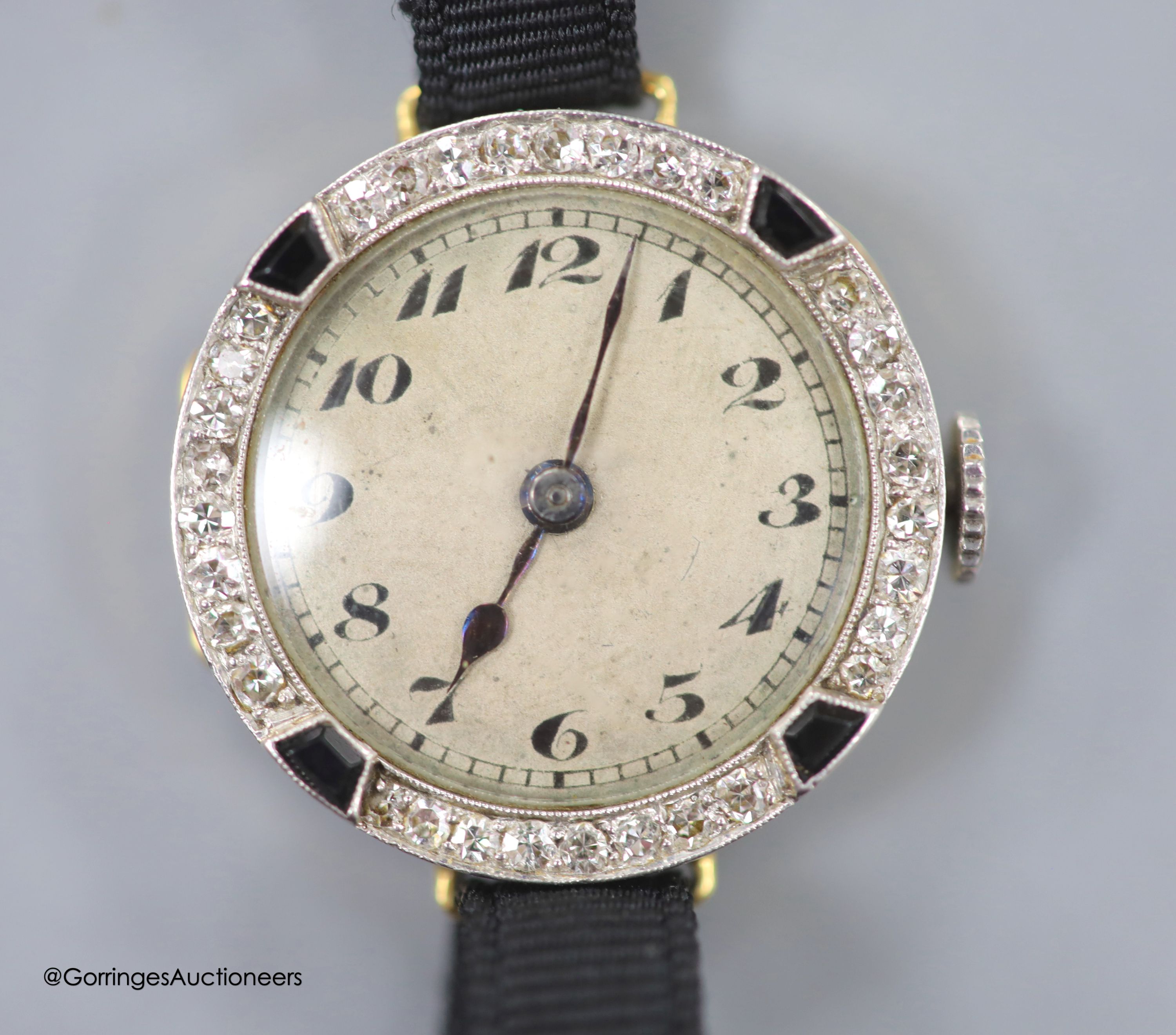 A lady's early 20th century 18ct gold, black onyx and diamond set cocktail watch, case diameter 21mm, on a fabric strap, gross weight 11.3 grams.